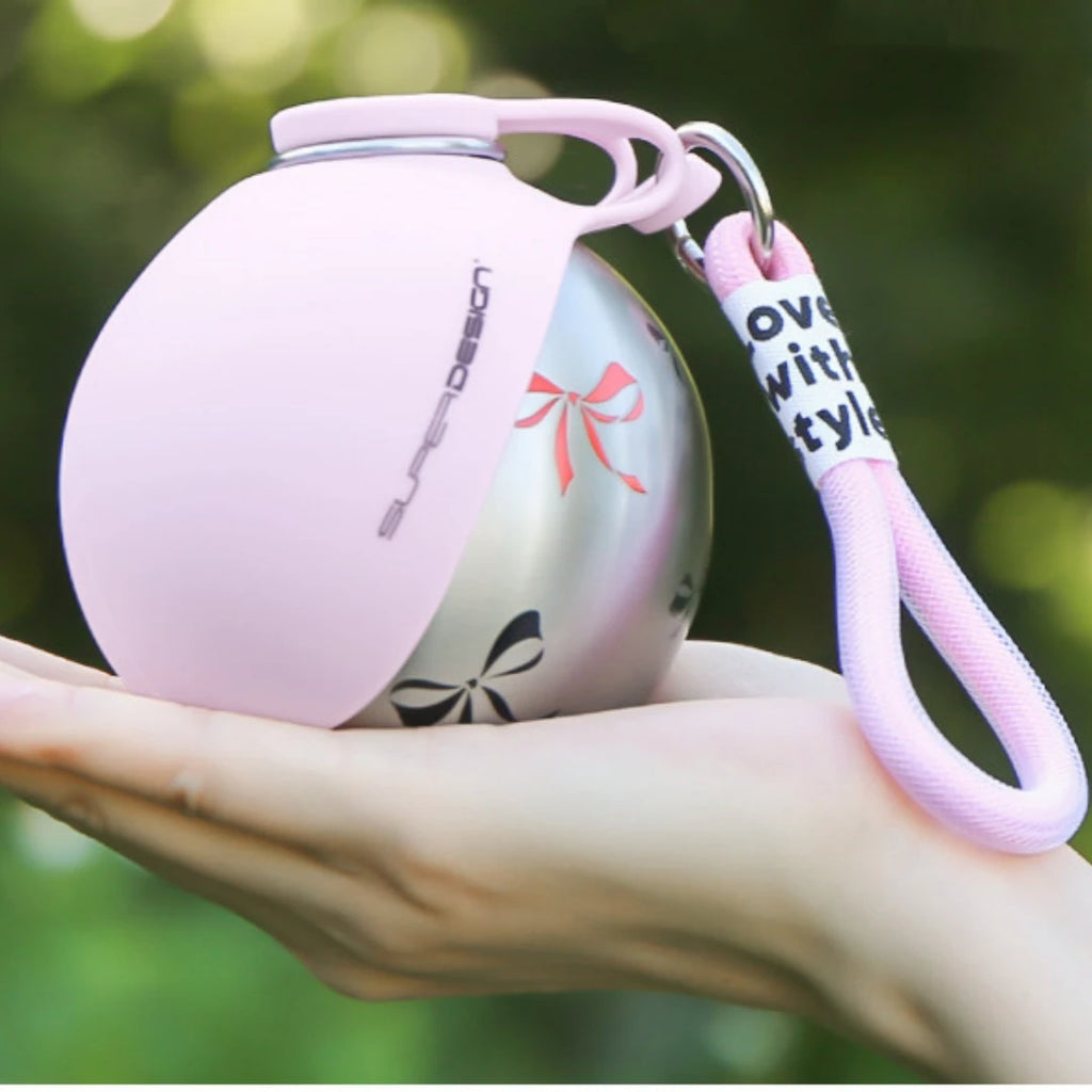 Paw Pack Bottle in Pink held in the palm of a hand — compact 285ml dog water bottle